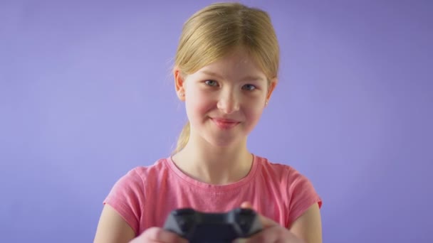 Mor Arka Planda Kumarda Oynayan Gülümseyen Bir Kızın Yavaş Çekimde — Stok video