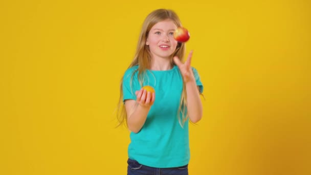 Syuting Studio Gadis Muda Juggling Apel Dan Oranye Terhadap Latar — Stok Video
