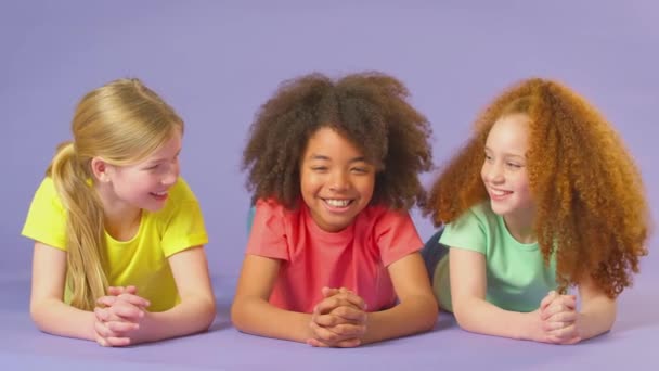 Retrato Estudio Tres Niños Amigos Tumbados Suelo Sobre Fondo Púrpura — Vídeos de Stock