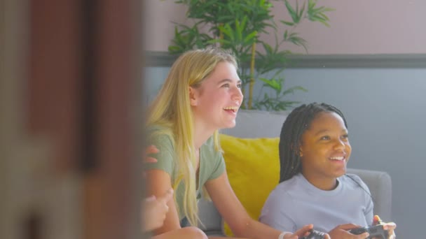 一群文化多元的少女朋友们坐在沙发上玩着好玩的游戏 呆在卧室里 慢镜头拍摄 — 图库视频影像