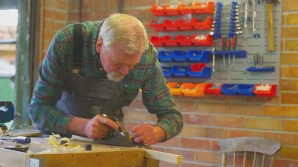 Senior Man Bär Overaller Hyvling Bit Trä Arbetsbänk Hemmet Garage — Stockvideo