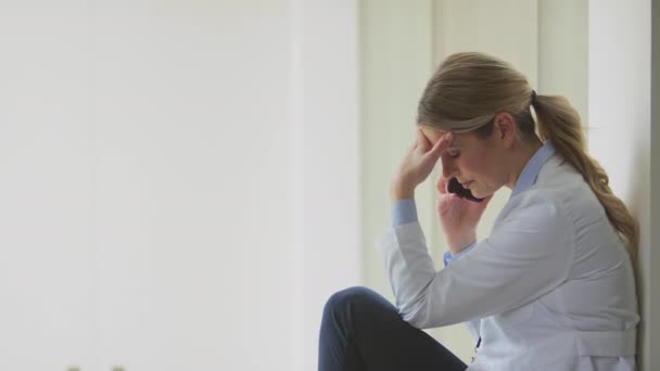 Stressed Male Doctor Wearing White Coat Sitting Desk Office Shot — Stock Video