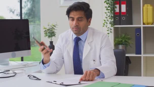 Portrait Male Doctor Wearing White Coat Thought Sitting Desk Office — Stockvideo