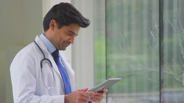 Manlig Läkare Bär Vit Rock Stående Sjukhuskorridoren Tittar Digital Tablett — Stockvideo
