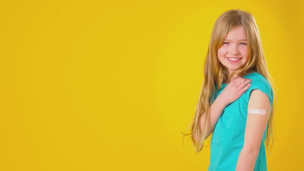 Στούντιο Πλάνο Του Χαμογελαστού Κοριτσιού Γύψο Κολλήσει Στο Χέρι Κοιτάζοντας — Αρχείο Βίντεο