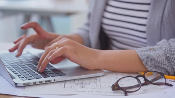 Крупный План Женщины Архитектора Работающей Ноутбуком Над Планами Столе Офисе — стоковое видео