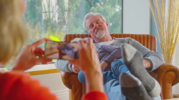 Бабушка Мобильным Телефоном Фотографирует Дедушку Внучку Спящих Днем Дома Вместе — стоковое видео
