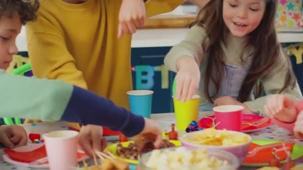 Niños Hambrientos Sentados Alrededor Mesa Fiesta Cumpleaños Comiendo Bocadillos Filmados — Vídeos de Stock