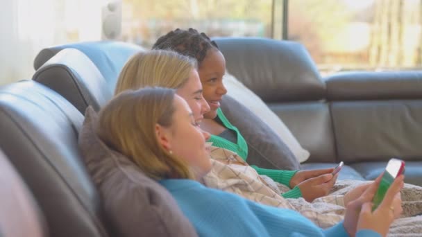 Group Multi Cultural Teenage Girl Friends Sitting Sofa Snuggled Blanket — Stock Video