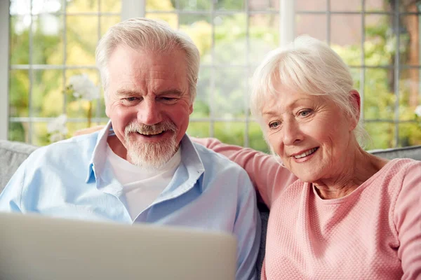 Retired Senior Couple Sitting Sofa Home Using Laptop — Stockfoto