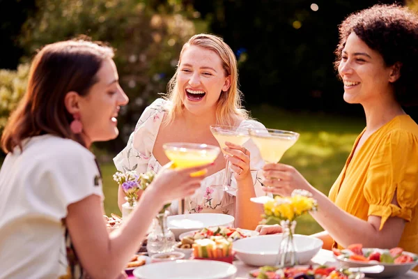 Three Female Friends Sitting Outdoors Summer Garden Home Drinking Cocktails — Stok fotoğraf