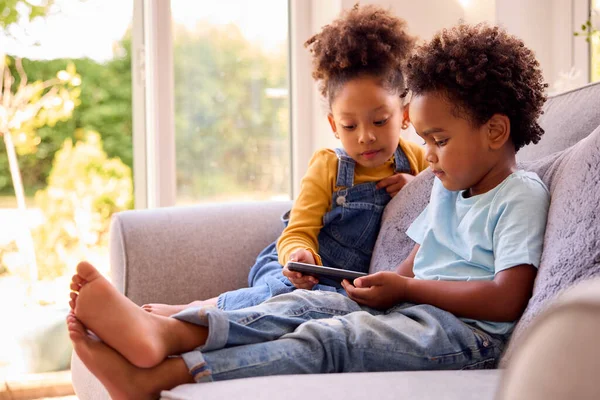Boy Girl Playing Handheld Computer Game Sitting Sofa Home Together — Φωτογραφία Αρχείου