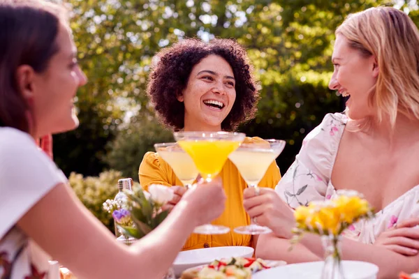 Three Female Friends Sitting Outdoors Summer Garden Home Drinking Cocktails — Φωτογραφία Αρχείου