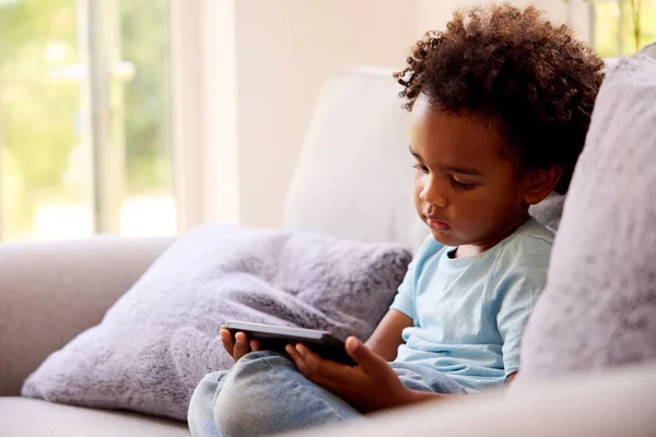 Boy Playing Handheld Computer Game Sitting Sofa Home — Φωτογραφία Αρχείου