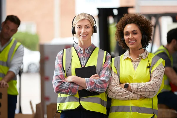 Portrait Two Female Workers Using Headsets Distribution Warehouse Digital Tablet — Stockfoto