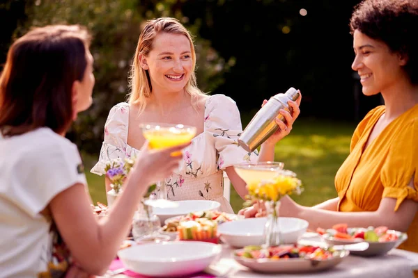 Three Female Friends Sitting Outdoors Summer Garden Home Drinking Cocktails — Stok fotoğraf