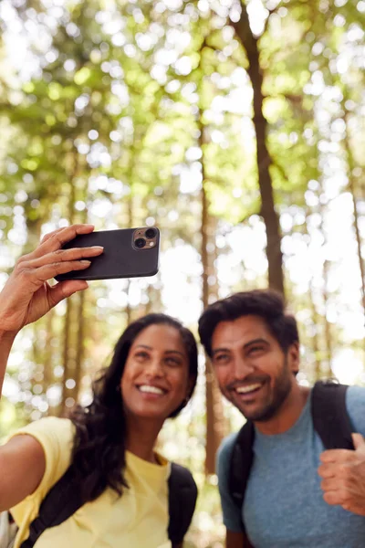 Couple Taking Selfie Mobile Phone Hiking Walking Woodland Countryside — Stock fotografie