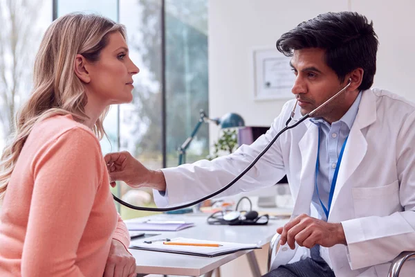 Male Doctor Wearing White Coat Examining Mature Woman Listening Chest — Stockfoto