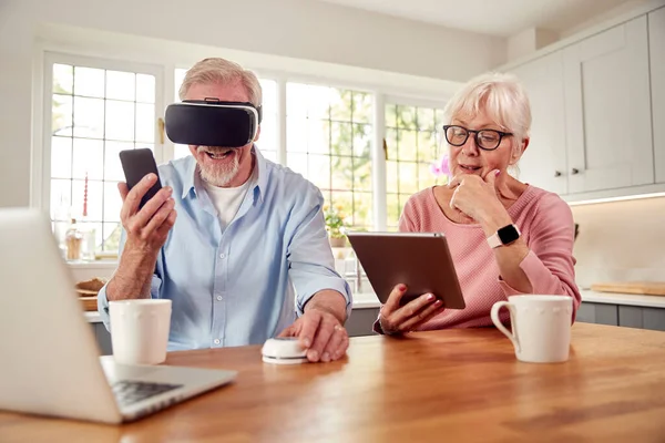 Retired Senior Couple Home Using Digital Tablet Headset Smartwatch Mobile — Foto de Stock