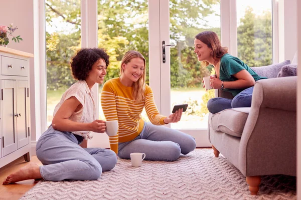Group Female Friends Relaxing Sofa Home Looking Mobile Phone Drinking — kuvapankkivalokuva