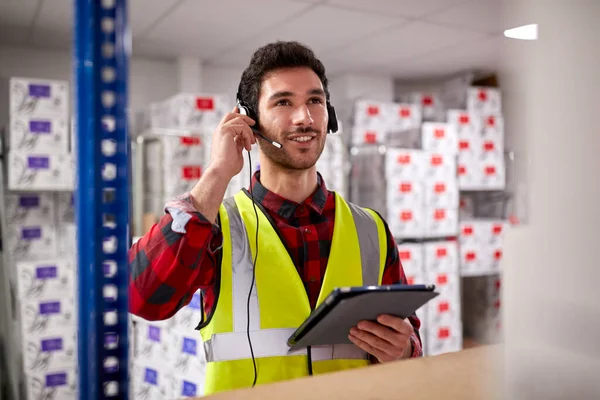Male Worker Wearing Headset Logistics Distribution Warehouse Using Digital Tablet — Stockfoto