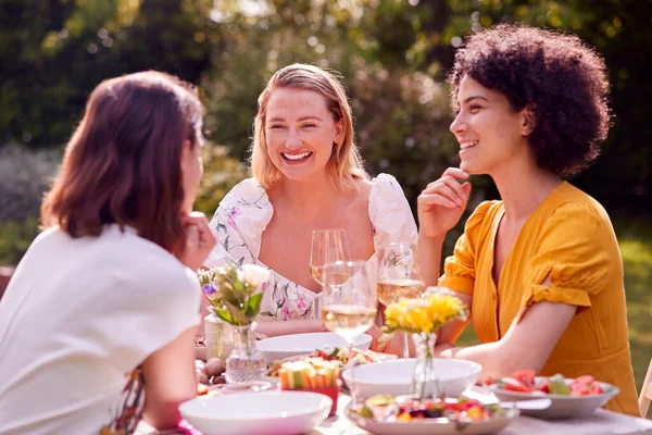 Three Female Friends Sitting Outdoors Summer Garden Home Eating Meal — Stok fotoğraf