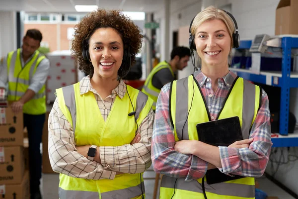 Portrait Two Female Workers Using Headsets Distribution Warehouse Digital Tablet — Stockfoto