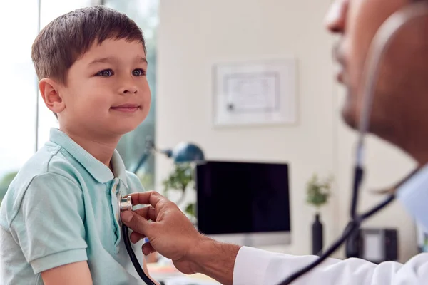 Male Doctor Wearing White Coat Examining Boy Listening Chest Stethoscope — Stockfoto