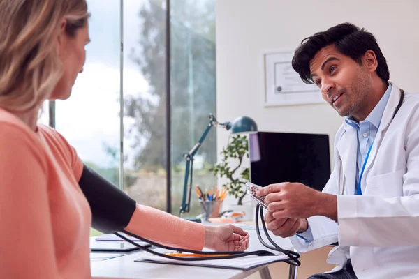 Male Doctor Examining Mature Female Patient Taking Blood Pressure Sphygmomanometer — Stockfoto
