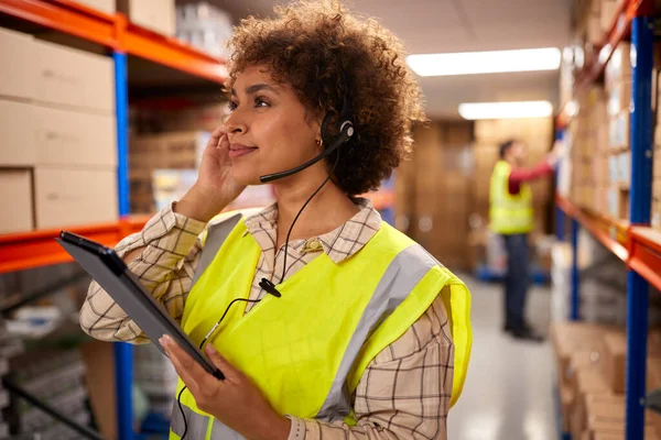 Female Worker Wearing Headset Logistics Distribution Warehouse Using Digital Tablet — Stockfoto