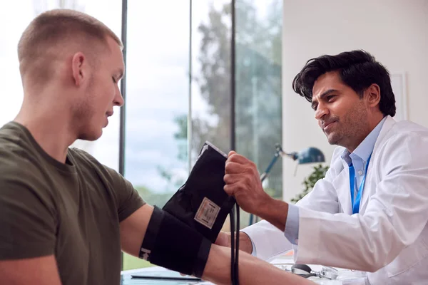 Male Doctor Examining Young Male Patient Taking Blood Pressure Sphygmomanometer — Stock Photo, Image