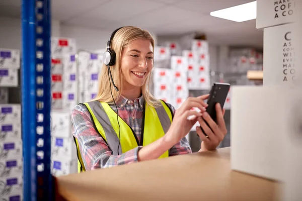 Female Worker Wearing Headset Logistics Distribution Warehouse Using Mobile Phone — Stockfoto