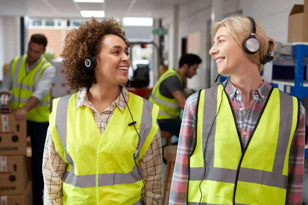 Two Female Workers Using Headsets Distribution Warehouse — Stockfoto