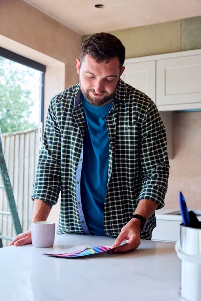 Man Renovating Kitchen Home Looking Paint Swatch Coffee Break — Stok Foto