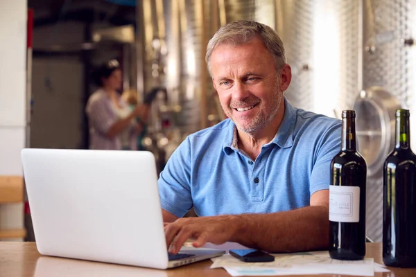 Volwassen Man Met Laptop Controleren Label Fles Binnen Wijnmakerij Met — Stockfoto