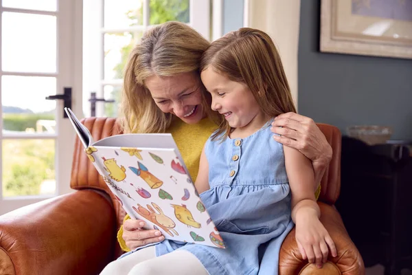 Família Com Mãe Filha Sentados Sofá Leitura Livro Casa Juntos — Fotografia de Stock