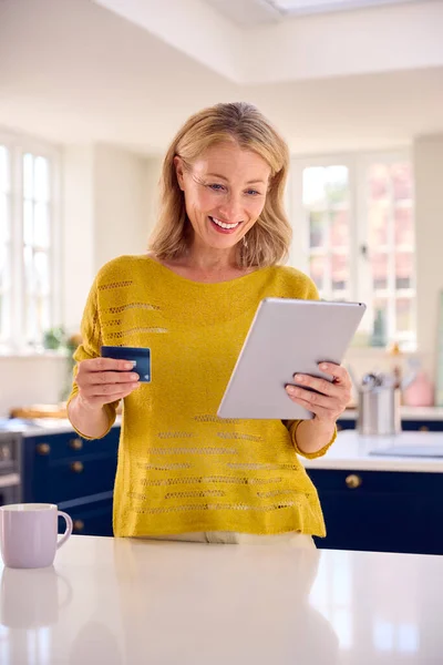Mature Woman Credit Card Using Digital Tablet Home Book Holiday — Stock Photo, Image