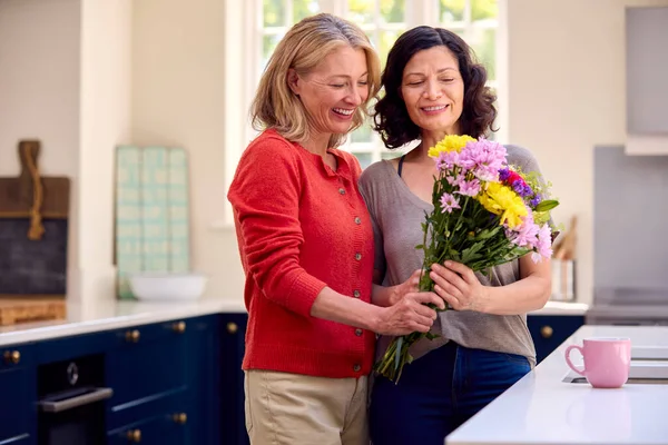 Mutfakta Eşine Çiçek Veren Kadın Eşli Aynı Cinsiyetten Olgun Çifti — Stok fotoğraf