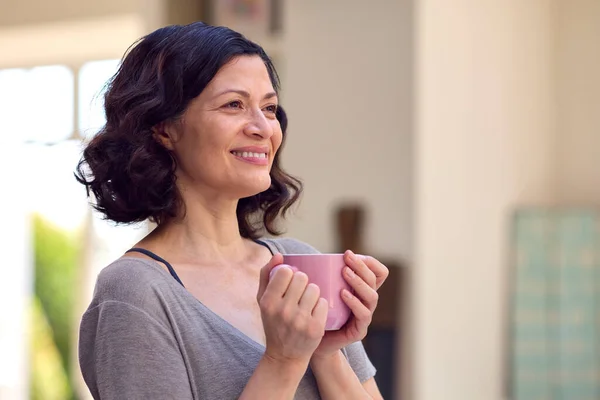 Uśmiechnięta Dojrzała Kobieta Stojąca Kuchni Relaksująca Się Filiżanką Kawy — Zdjęcie stockowe