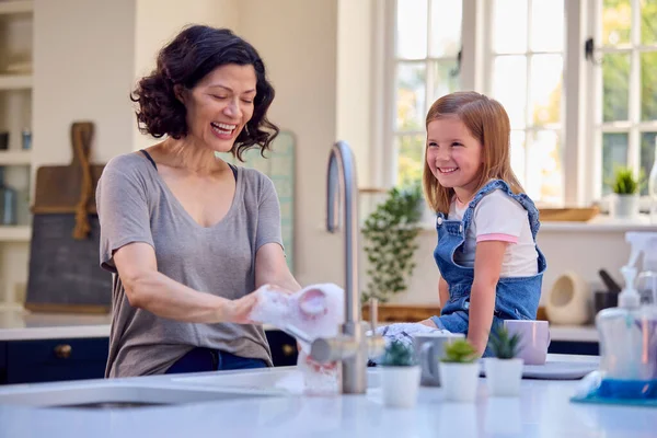 Οικογένεια Την Κόρη Βοηθώντας Μεγαλύτερη Μητέρα Κάνει Πλύσιμο Στην Κουζίνα — Φωτογραφία Αρχείου
