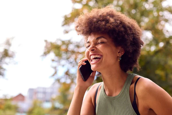 Glimlachende Jonge Vrouw Buiten Lachen Als Praat Mobiele Telefoon — Stockfoto