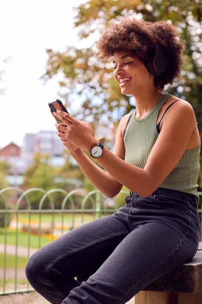 Молодая Женщина Улице Носит Беспроводные Наушники Потоковое Шоу Мобильного Телефона — стоковое фото
