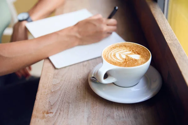コーヒーショップウィンドウでの女性の顧客の閉鎖ノートブックでの作業 — ストック写真