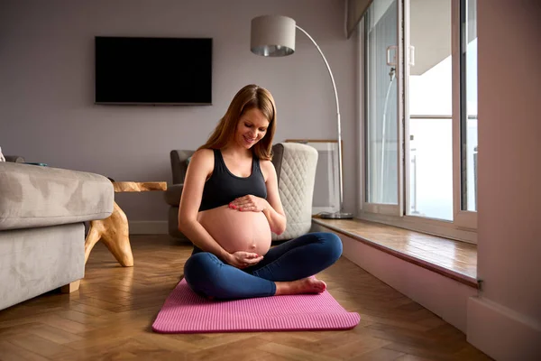 Mujer Embarazada Usando Ropa Fitness Estera Ejercicio Casa Haciendo Yoga —  Fotos de Stock