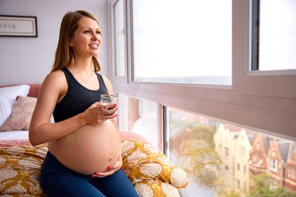 Těhotná Žena Teplým Pitím Relaxační Posteli Doma Držení Břicha — Stock fotografie