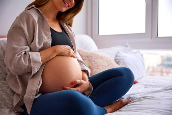 Έγκυος Γυναίκα Χαλαρώνοντας Στο Κρεβάτι Στο Σπίτι Εκμετάλλευση Στομάχου — Φωτογραφία Αρχείου