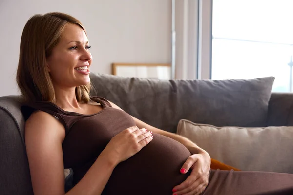 Gravid Kvinna Avslappnande Soffan Hemma Håller Mage — Stockfoto