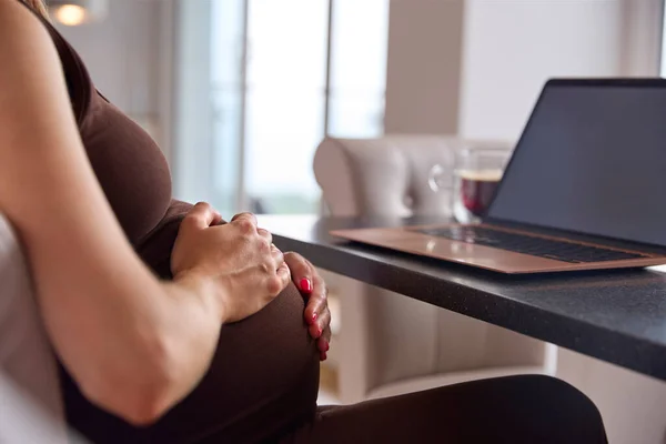 坐在笔记本电脑上 手握大锅 在家工作的孕妇的近视 — 图库照片