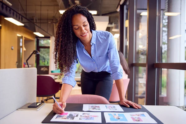 商业妇女站在公开计划办公室的桌旁批准或核对计划书或设计布局 — 图库照片