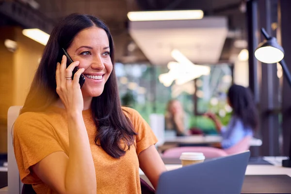 Бізнес Леді Сидить Столі Офісі Працює Ноутбуці Розмовляючи Мобільному Телефоні — стокове фото